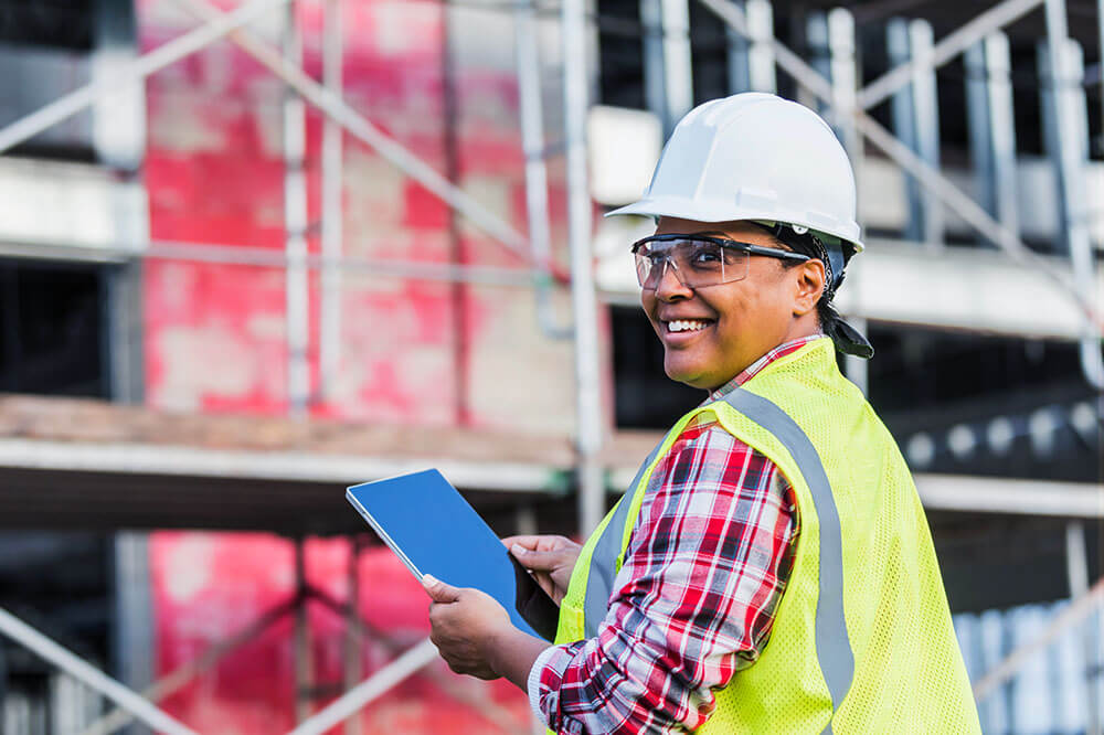 backoff_1 female construction worker holding a tablet and smiling