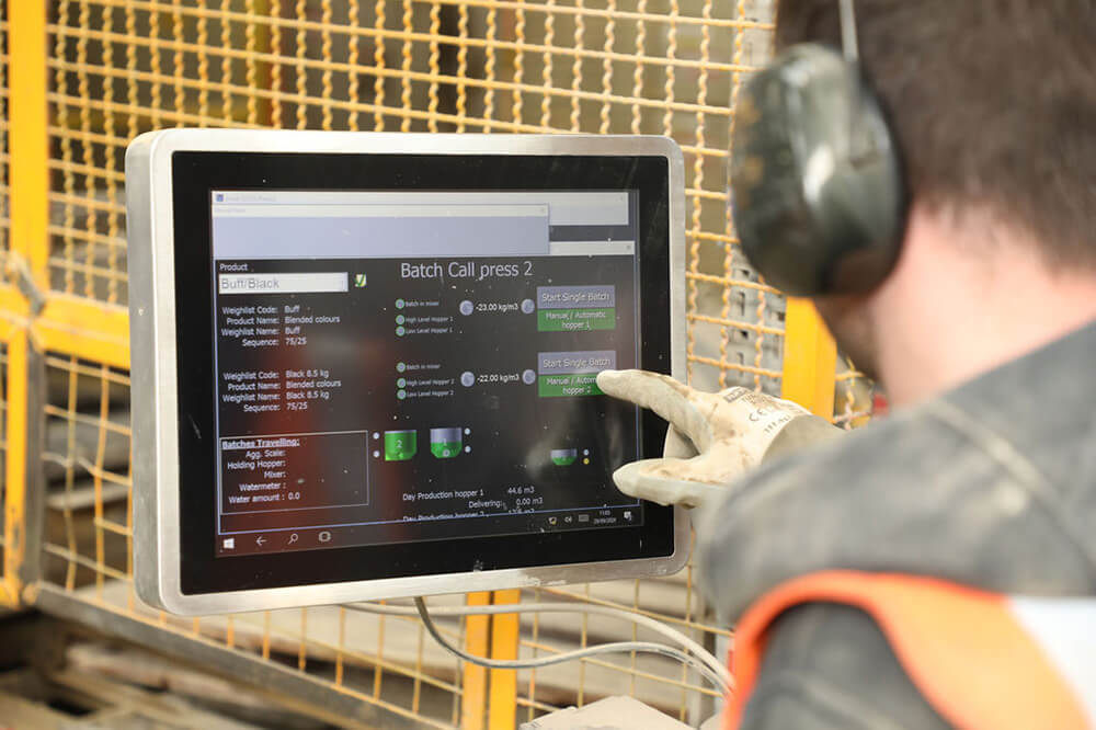 REMOTE OPERATOR INTERFACE Construction man in hardhat on site using a tablet to work
